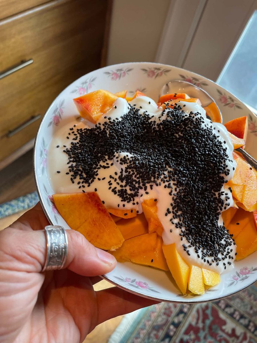 A bowl of fresh organic fruit topped with seeds
