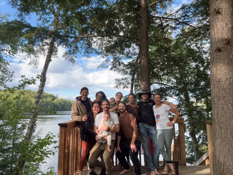 Retreat group gathered on the lakeside deck under tall pines